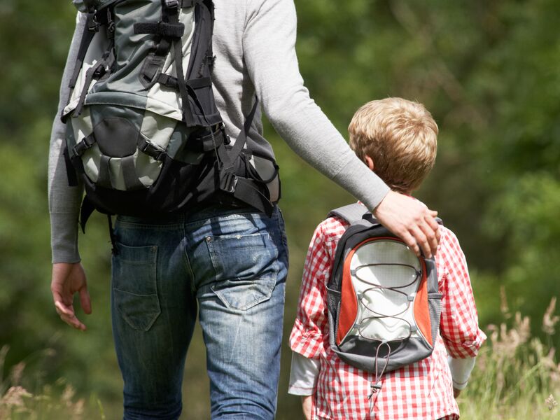 Ein Mann und ein Junge mit Rucksäcken wandern im Freien.